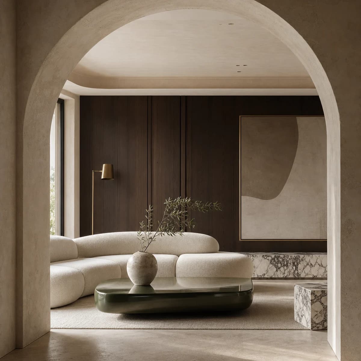 European-inspired living room framed by a limestone arch, with sculptural seating, fumed oak, and Calacatta stone